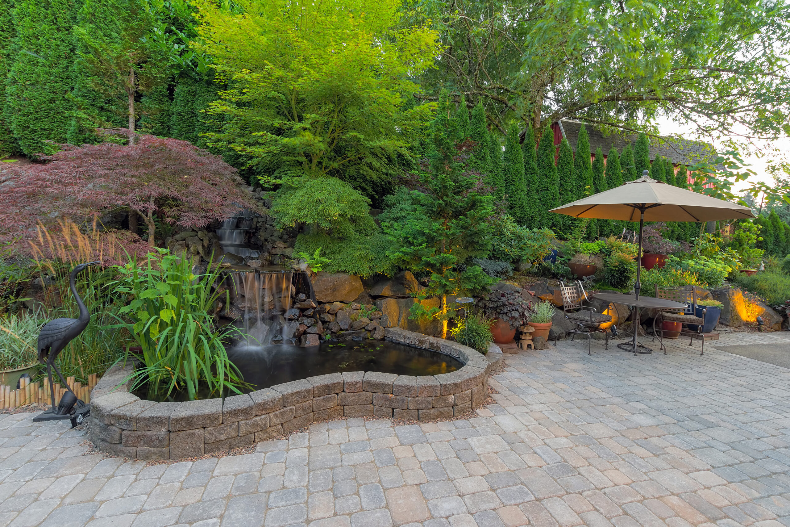 Backyard Garden landscaping with waterfall pond trees plants trellis decor furniture brick pavers patio hardscape